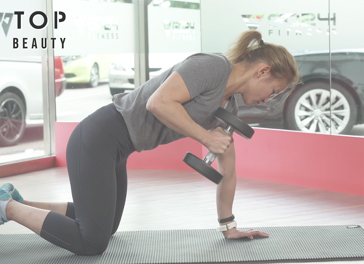 單手握啞鈴,上身和上臂保持不動,腰背挺直