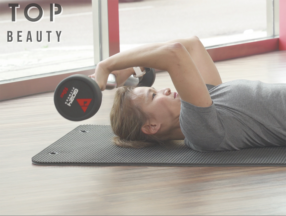 將啞鈴放下至耳朵兩旁,三頭肌發力,將槓鈴舉回到起始位置