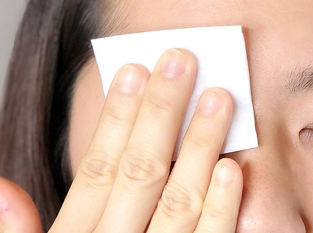 修眉前先用化妝棉熱敷眉毛。