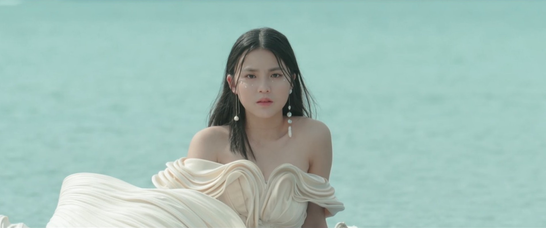 Chantel身穿露肩裝束漂浮在海中央,臉上畫著水滴妝容