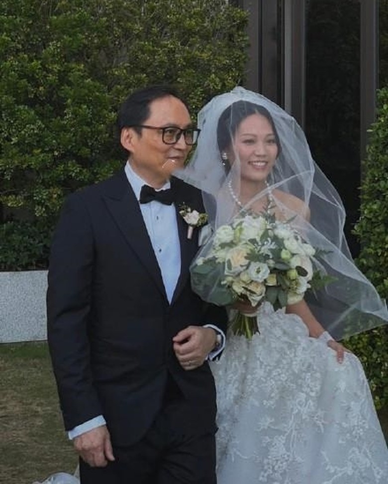 身穿婚紗的Caroline挽住爸爸霍文遜進場