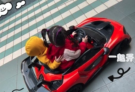 女兒學爸爸一樣坐玩具車通處跑,十分幸福!