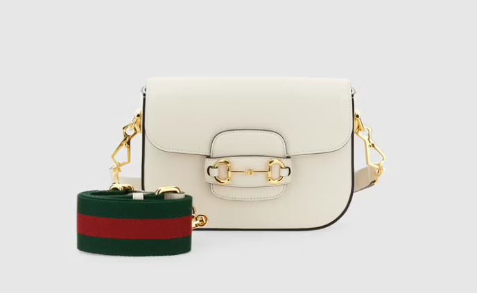 Gucci馬銜扣1955迷你袋款以白色皮革配有兩條不同色調的肩帶。