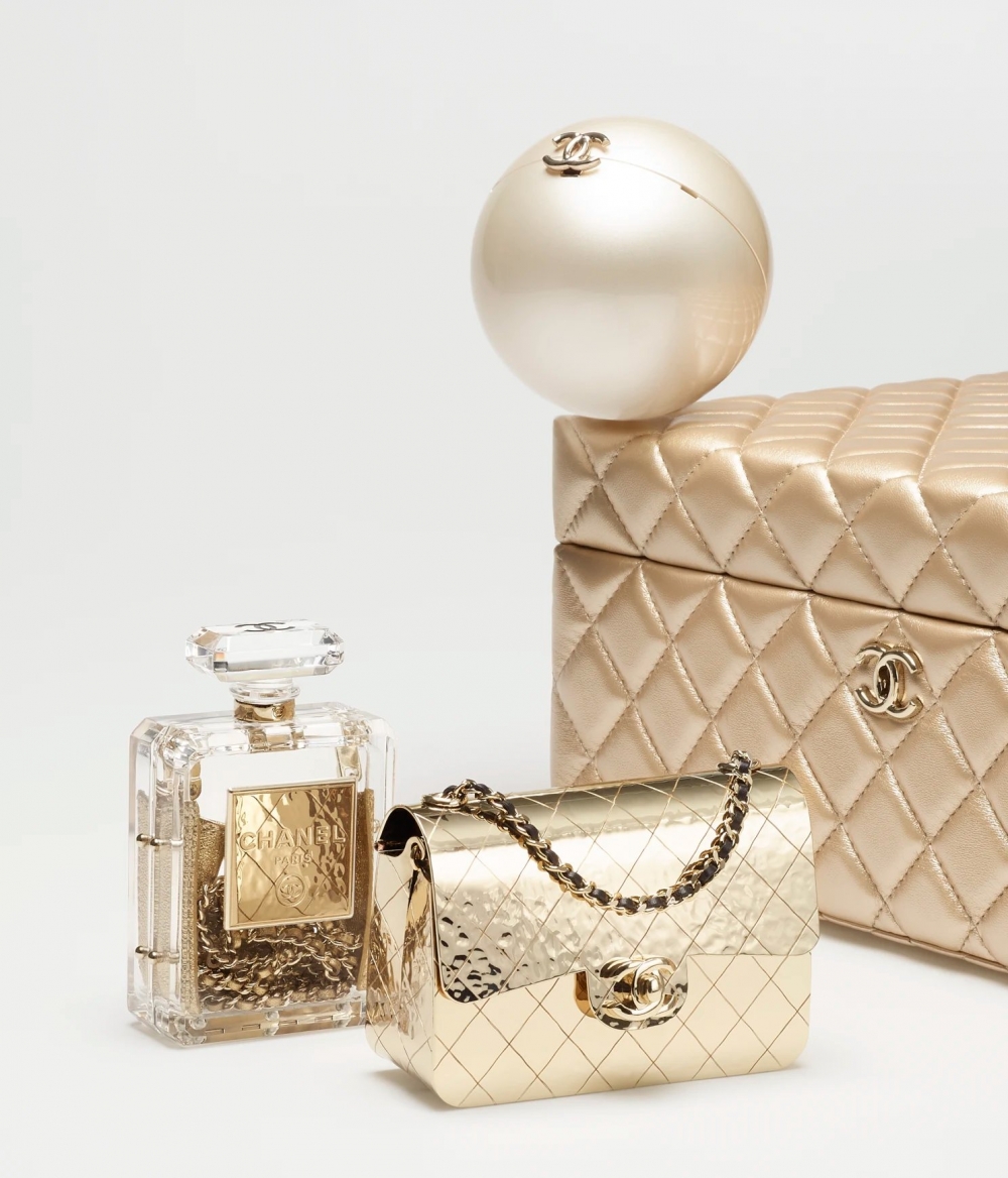CHANEL禮盒有樹脂香水瓶、一個帶有CC標誌扣環的圓形珍珠寶貝球以及由金色金屬製成的Flap Bag!
