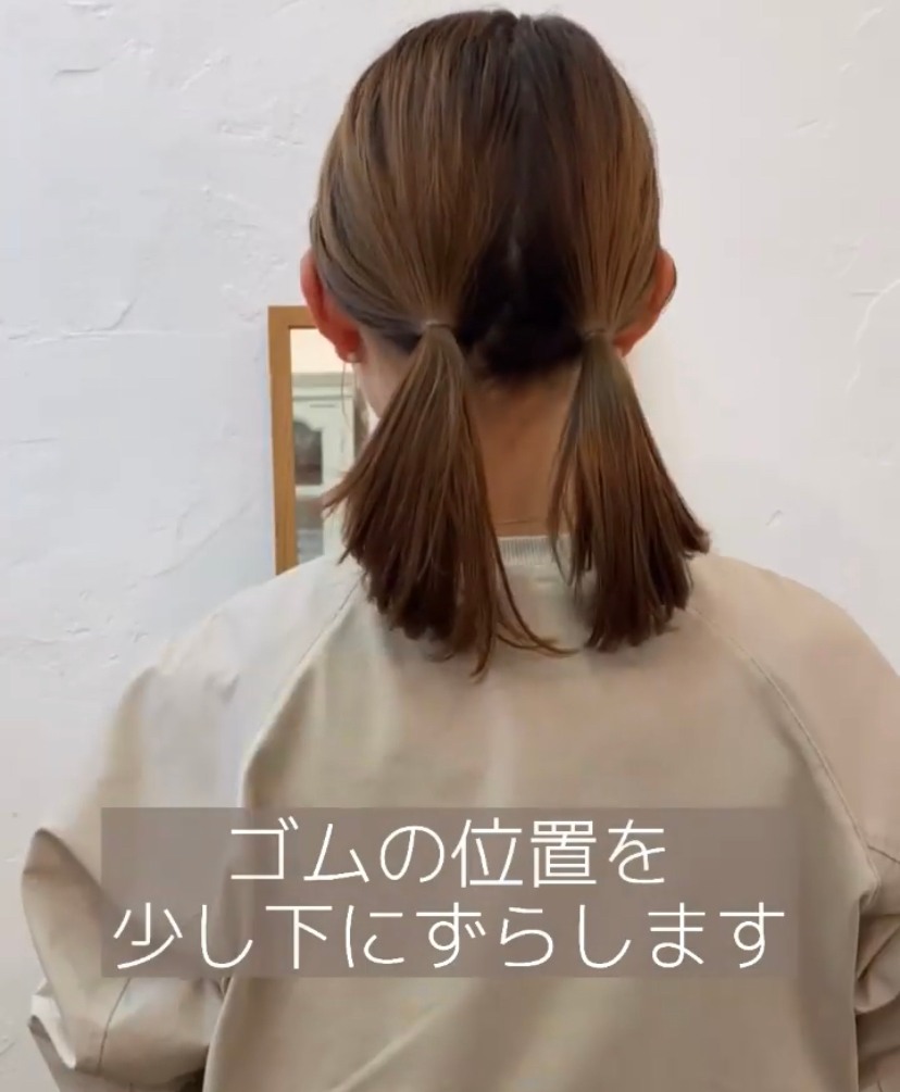 將頭髮分成左右兩邊,各紮一個低馬尾。