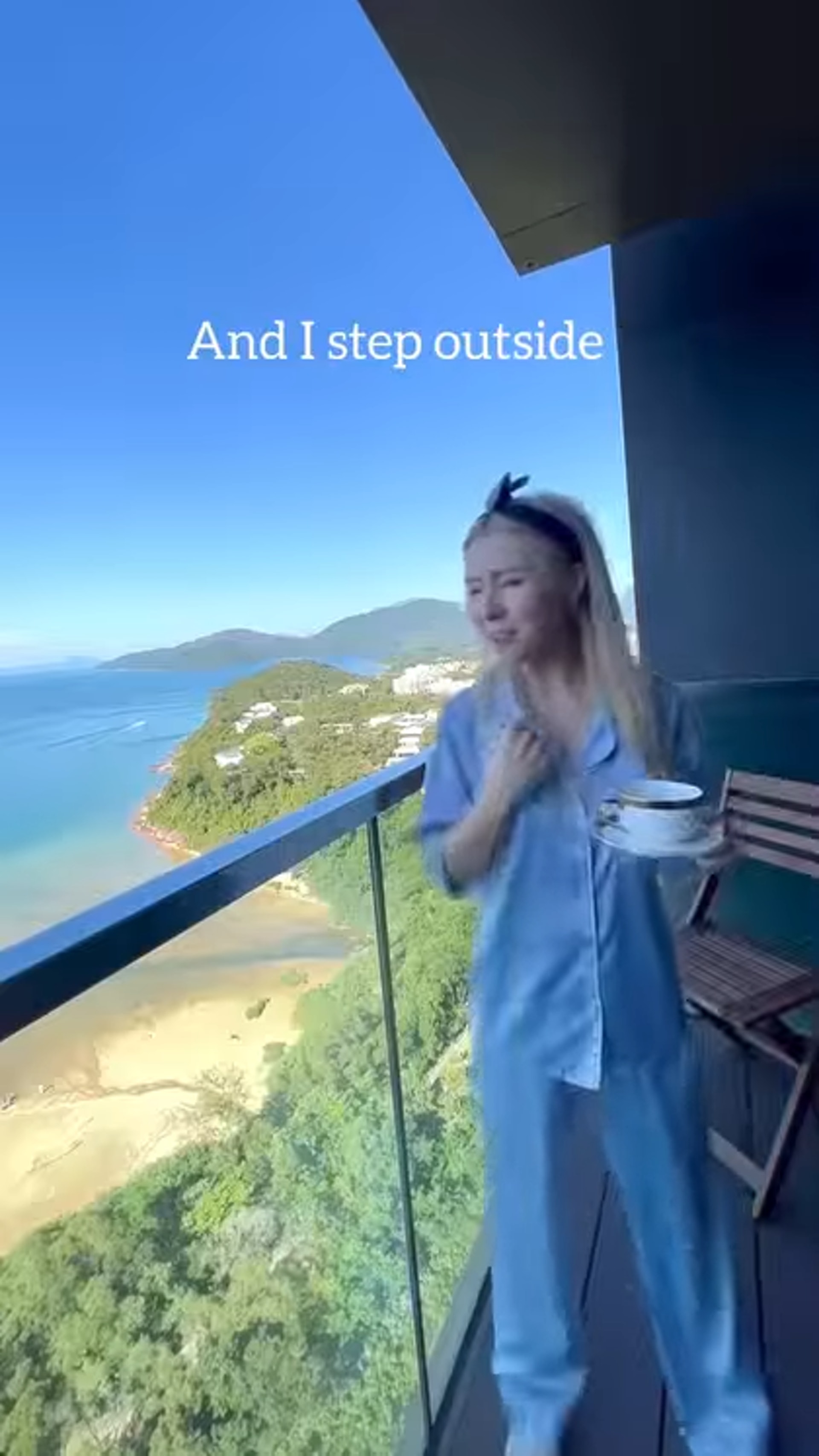 譚嘉儀站在露台望向海景。