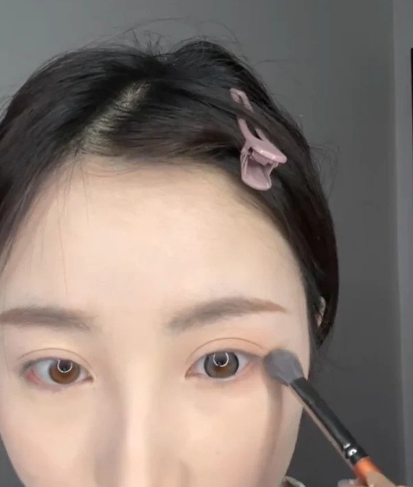 用化妝掃來掃眼影。