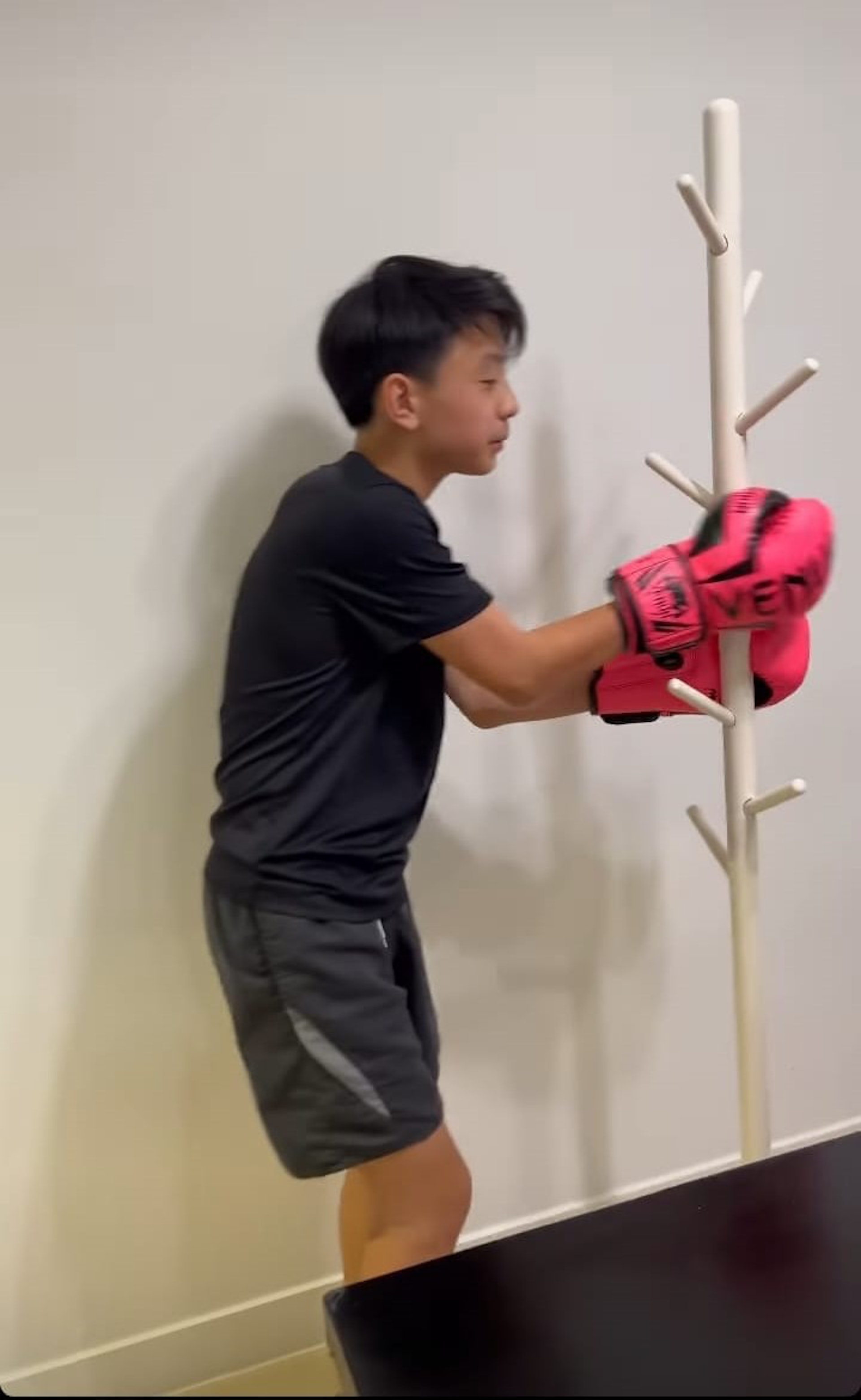 Quintus一身運動裝束,戴上拳套準備練拳,不過打的並非詠春的木人樁而是宜家的掛衫架。