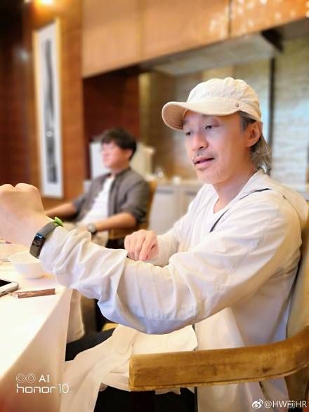 相中所見星爺身穿白色外套頭戴白色Cap帽