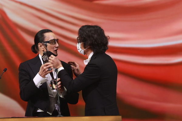 謝賢在台上多次試圖拉低口罩亦被林家棟阻止。