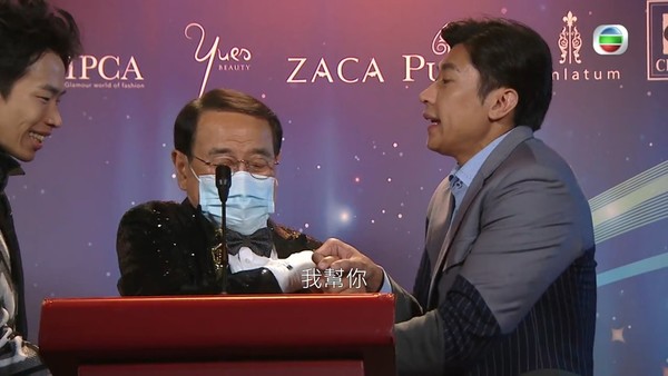 根叔在台上想除口罩表達感言。