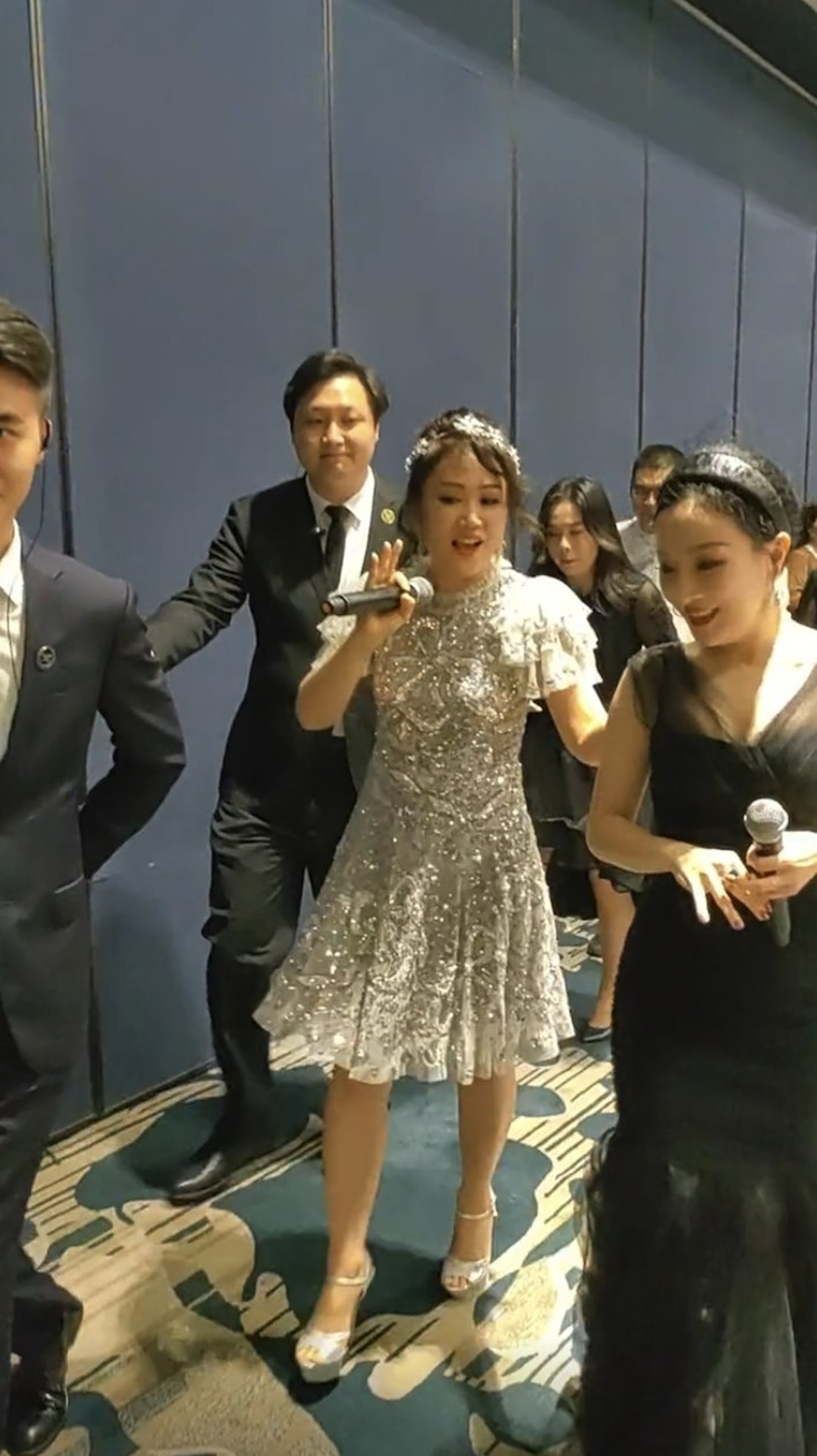 梁小冰化上精緻妝容並身穿Bling Bling連身裙，在保鑣的保護下行上台。