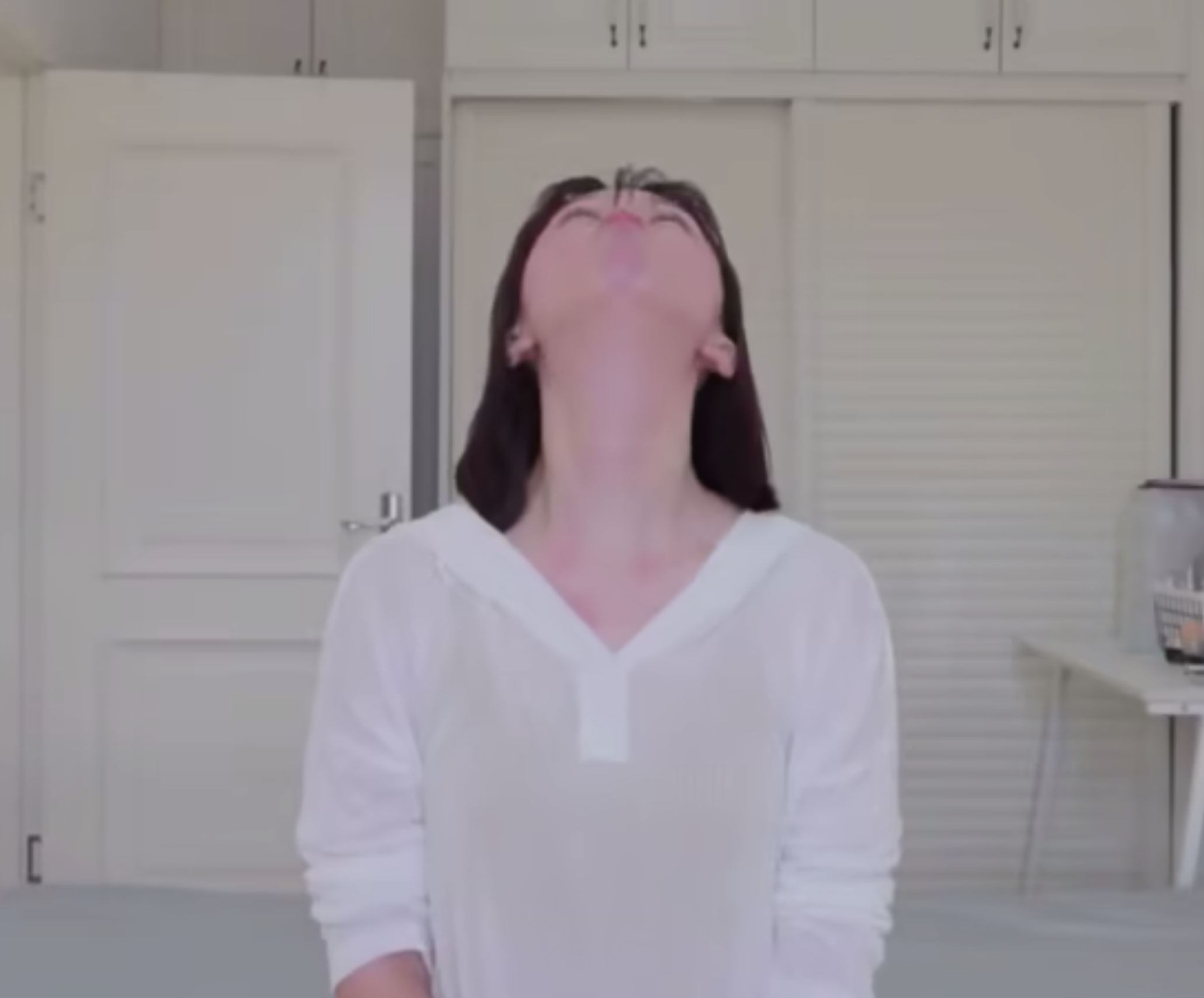 抬起頭望向天花板,當頭向上擺時嘟起嘴