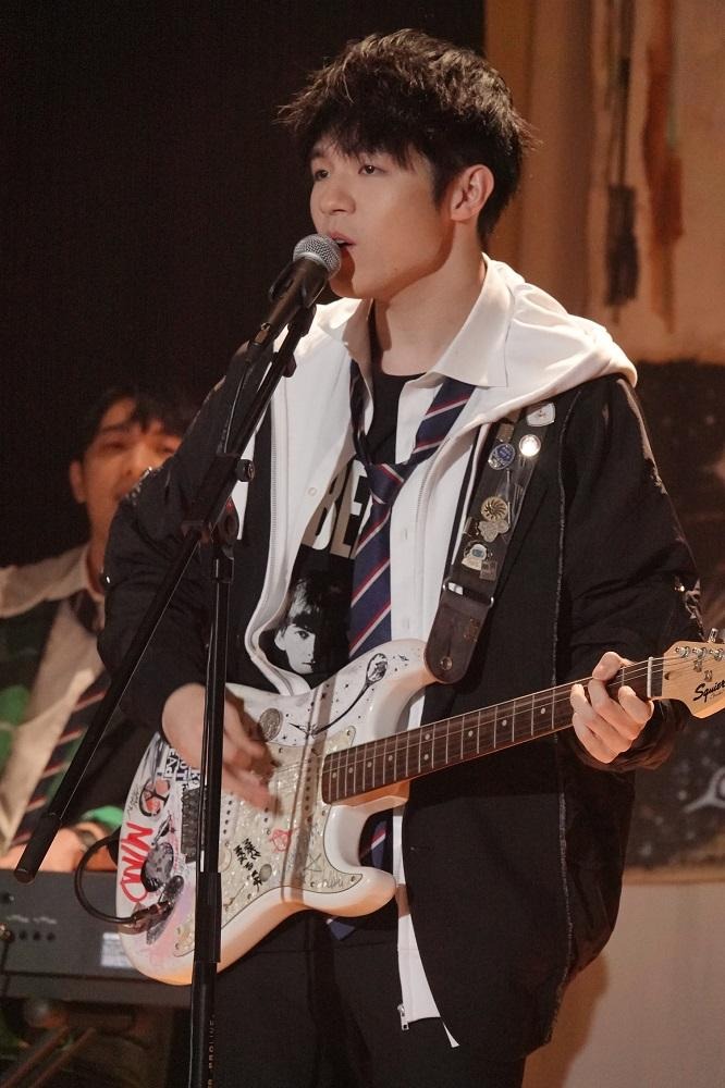 Ian穿上中學校服,拿起結他在禮堂夾Band。
