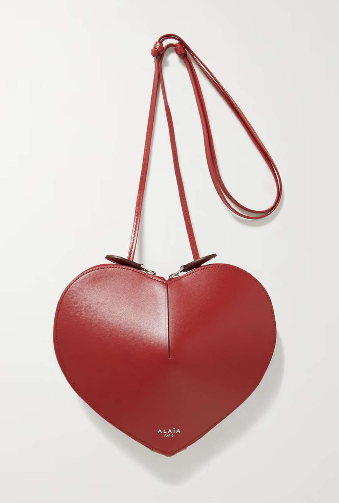 這款心型手袋以光滑的牛皮製作,配有可調式肩帶