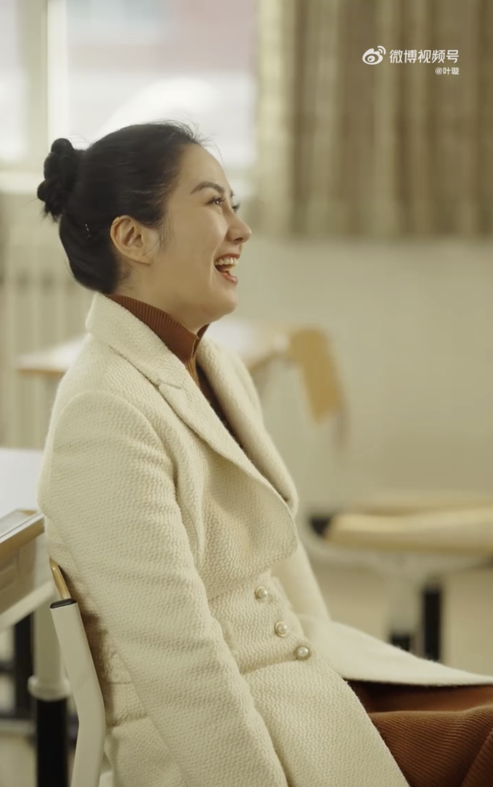 葉璇身穿淺杏色外套內襯咖啡色高領上衣,綁著俐落的丸子頭。