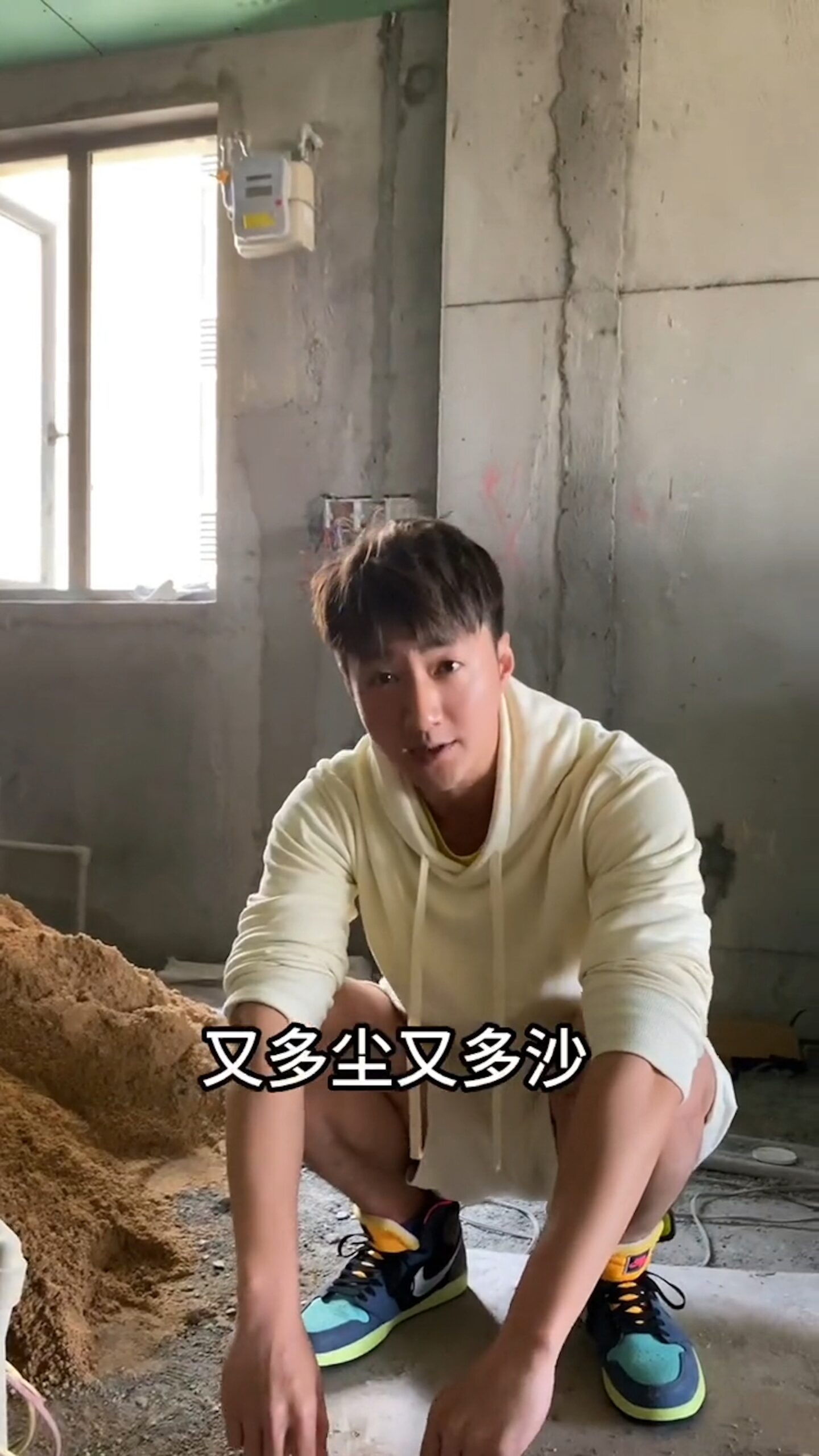 蔡淇俊蹲在一堆沙的旁邊,稱地盤真的又多塵又多沙。