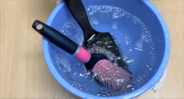 將頭皮按摩梳浸泡在溫水中。
