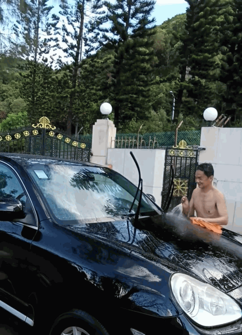 黃光亮只穿上短褲,親自拿住抹布洗車。