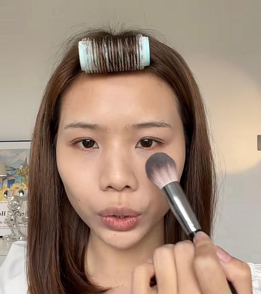 用化妝掃沾取適量蜜粉，以輕輕按壓的方式點在面上和眼下位置作定妝。