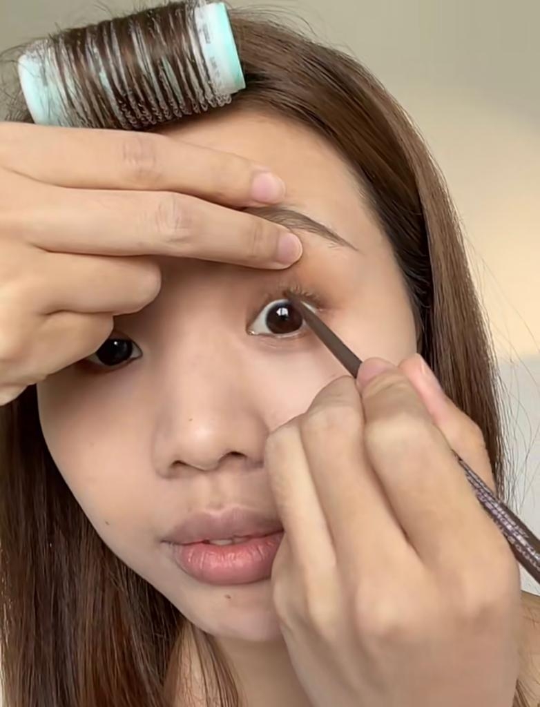 把睫毛夾翹，再用眼線筆畫上內眼線。