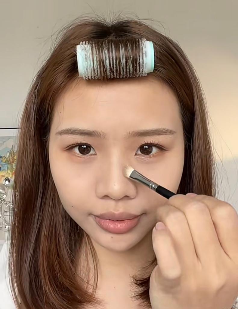 用小號化妝掃沾點棕灰色眼影，由山根開始慢慢向鼻樑下輕掃。