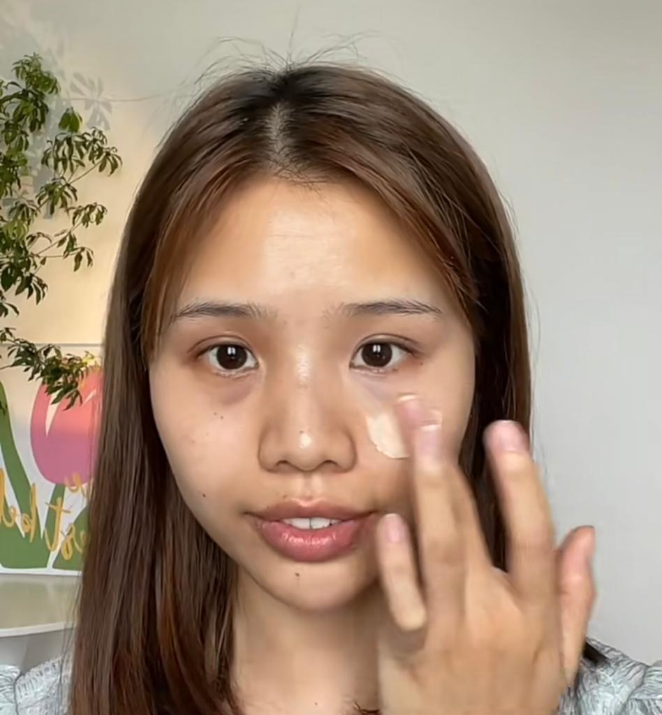 用手先乳化一下遮瑕膏，再以指腹點在黑眼圈上。