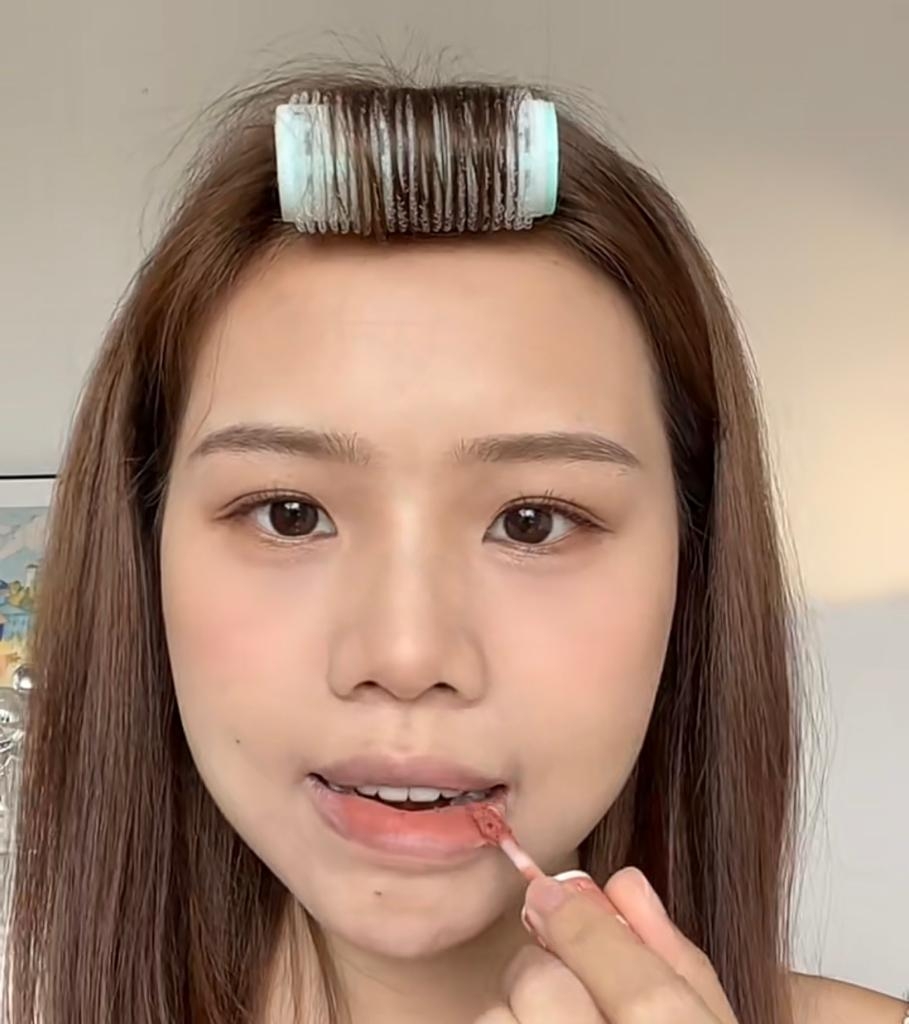 用粉樸沾點粉底液，輕印於唇上略略遮蓋原來唇色，再塗抹杏色唇膏。