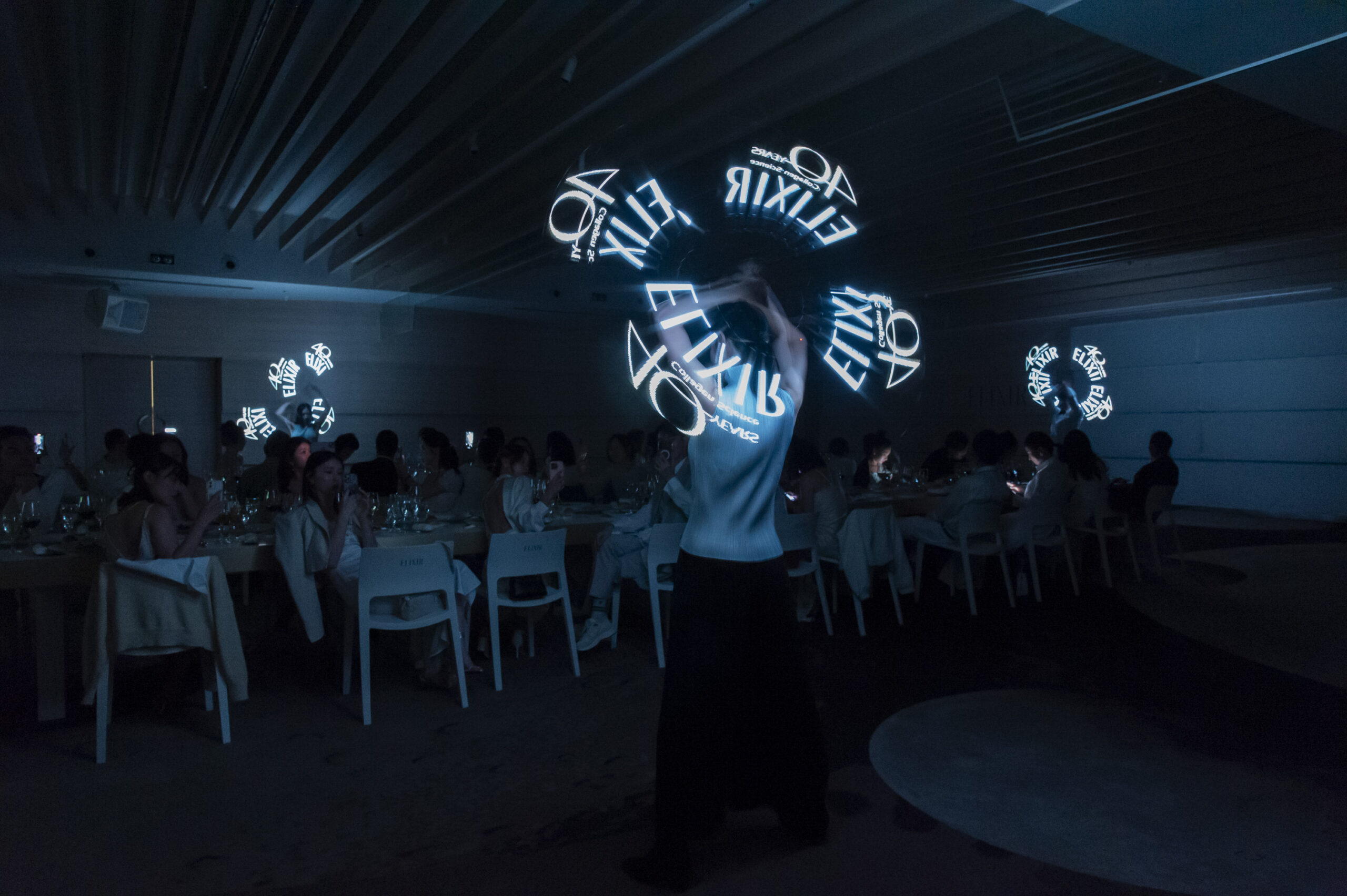 表演者快速揮動LED光條組成ELIXIR字樣