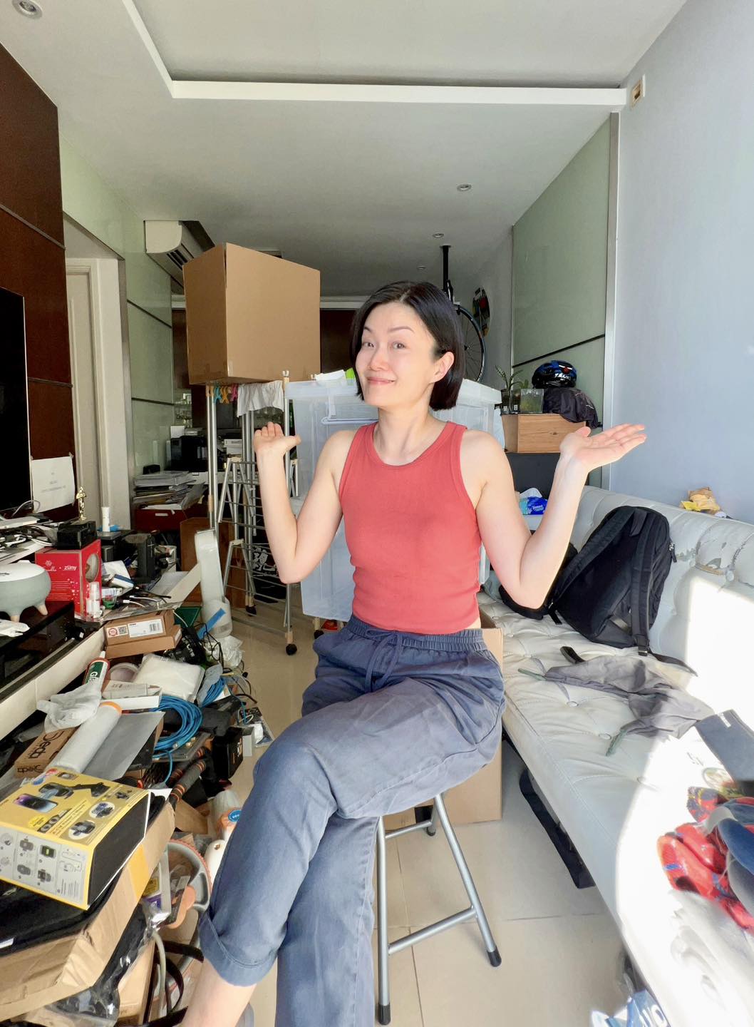 方健儀坐在凌亂的客廳中間，並表示自己執屋非常緩慢。