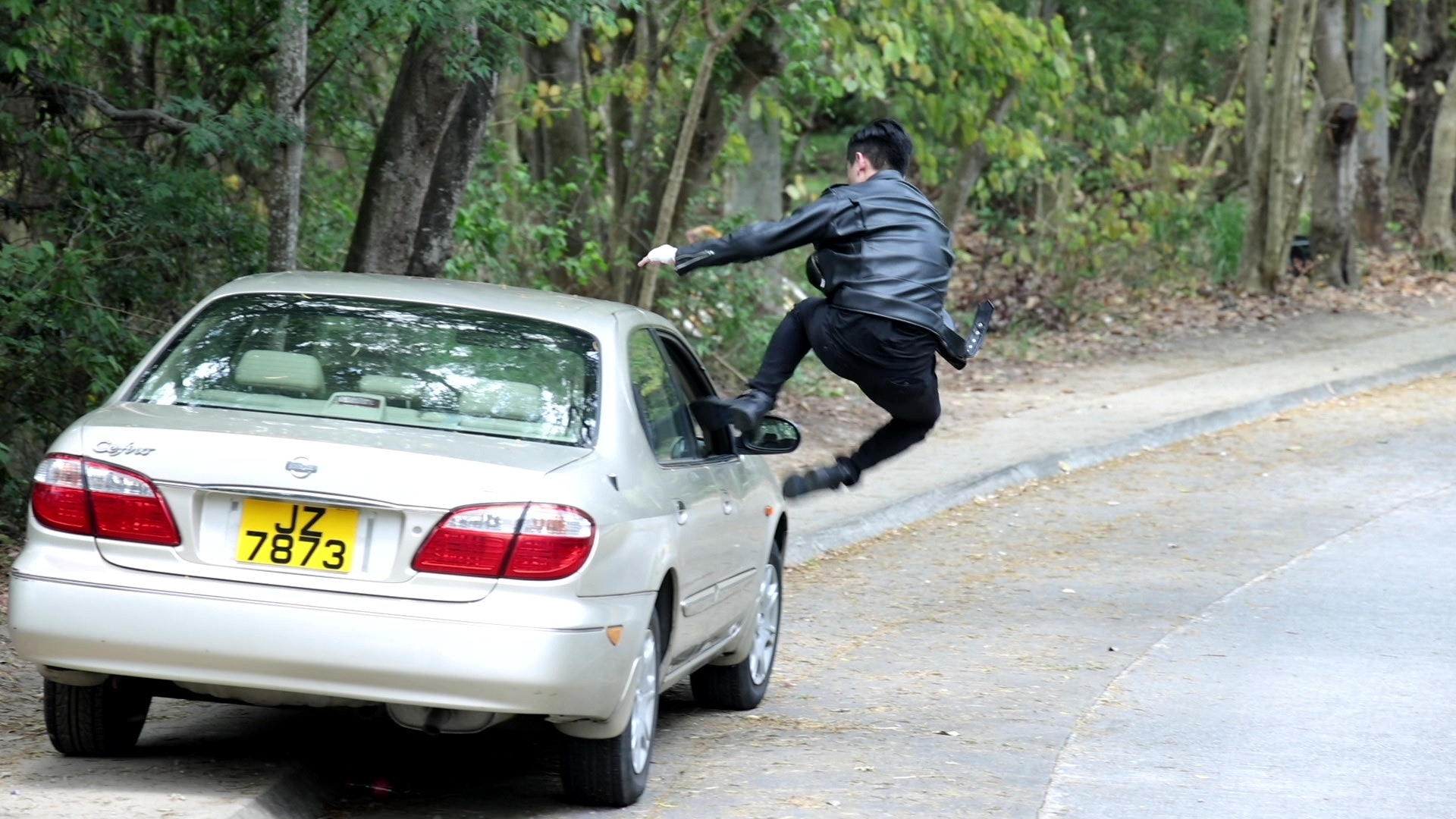 一躍飛身從車窗跳入私家車司機位。