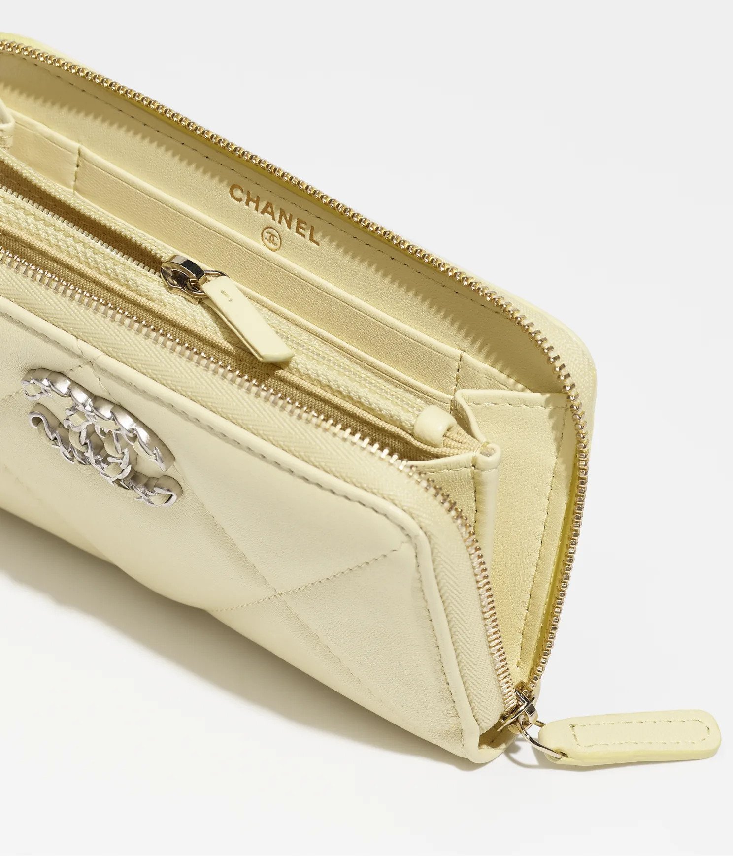 這款淺黃色銀包用色活潑，用上由Chanel 19手袋為靈感的設計，以光面小羊皮製成。