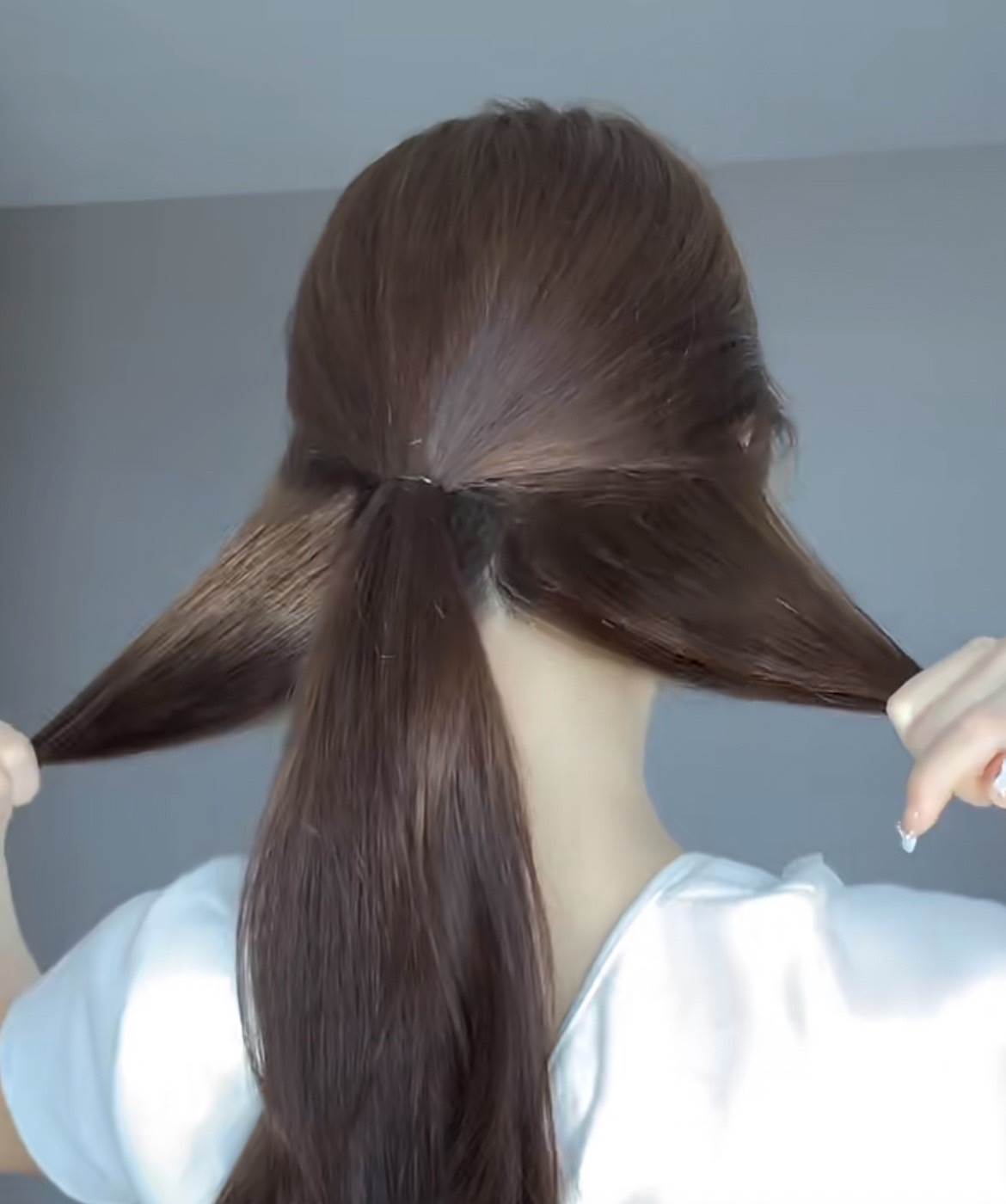 先取出2/3的頭髮,用髮圈綁起來,下方的頭髮分成2份。