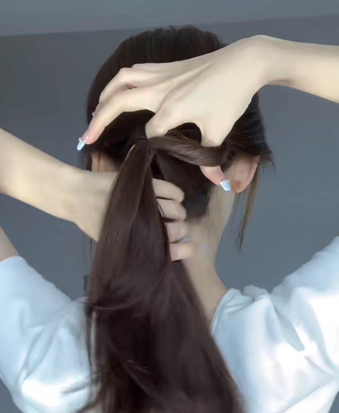 將上方的髮束拉出1個小圈,並扭轉1圈。