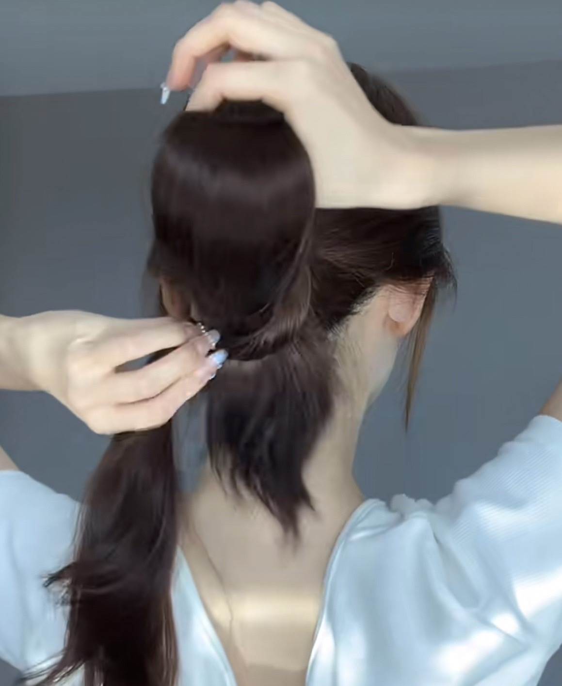 然後把下方的馬尾穿過剛剛扭轉的圈圈。