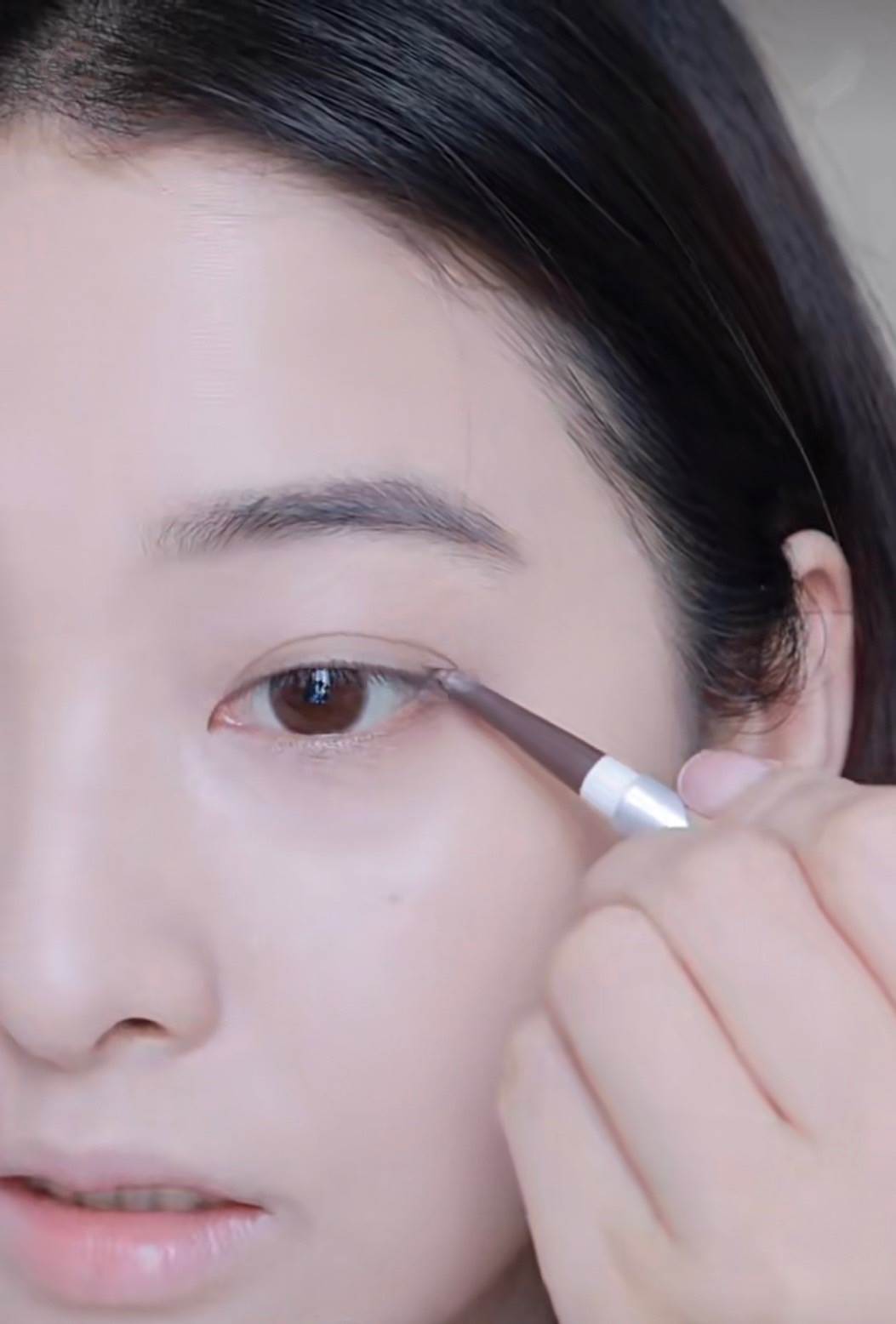 用棕色的眼線筆將眼尾拉長一點，畫出自然的眼線。