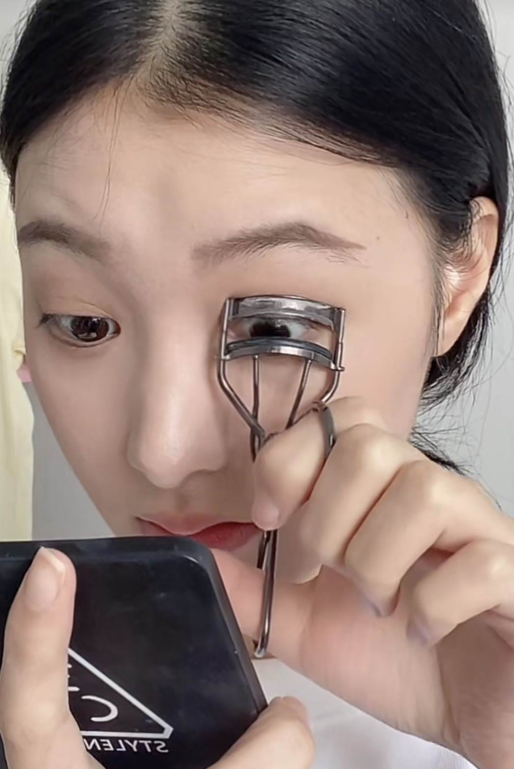 用睫毛夾將睫毛夾翹。