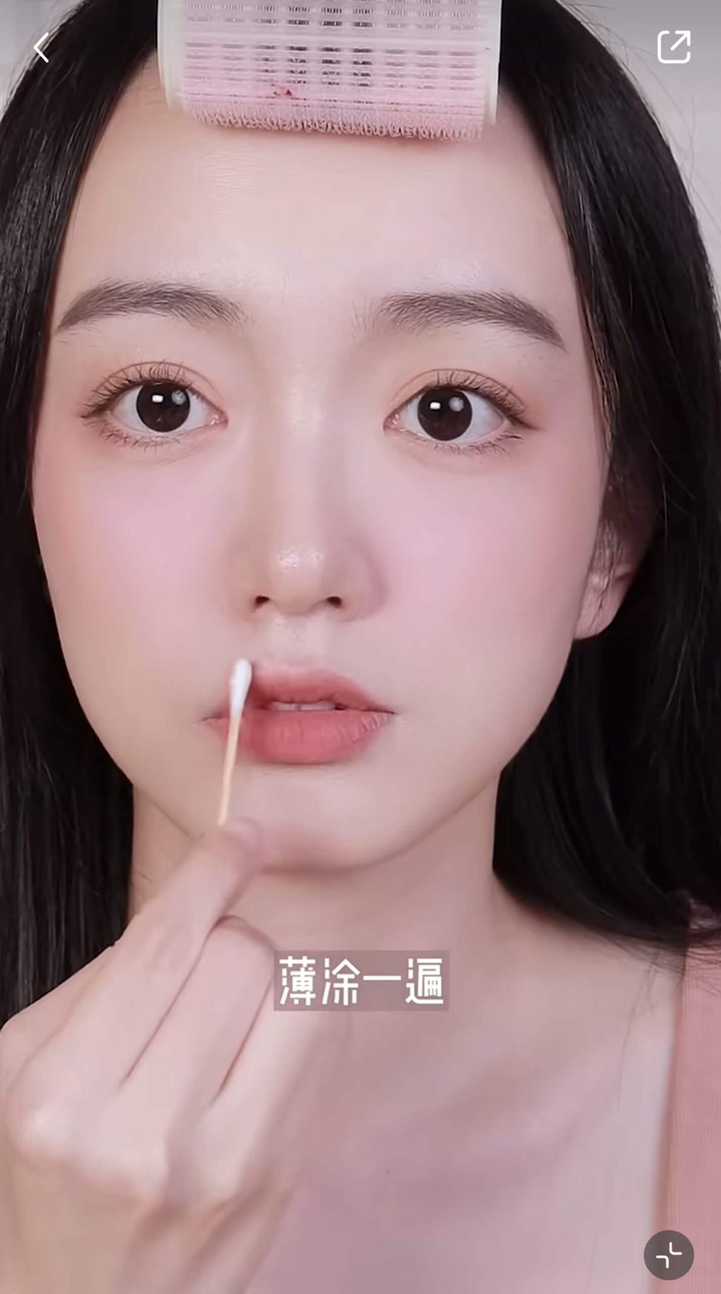 先用一個灰粉色的唇妝產品打底，再用磚紅色唇彩在上下唇畫出一個V字。