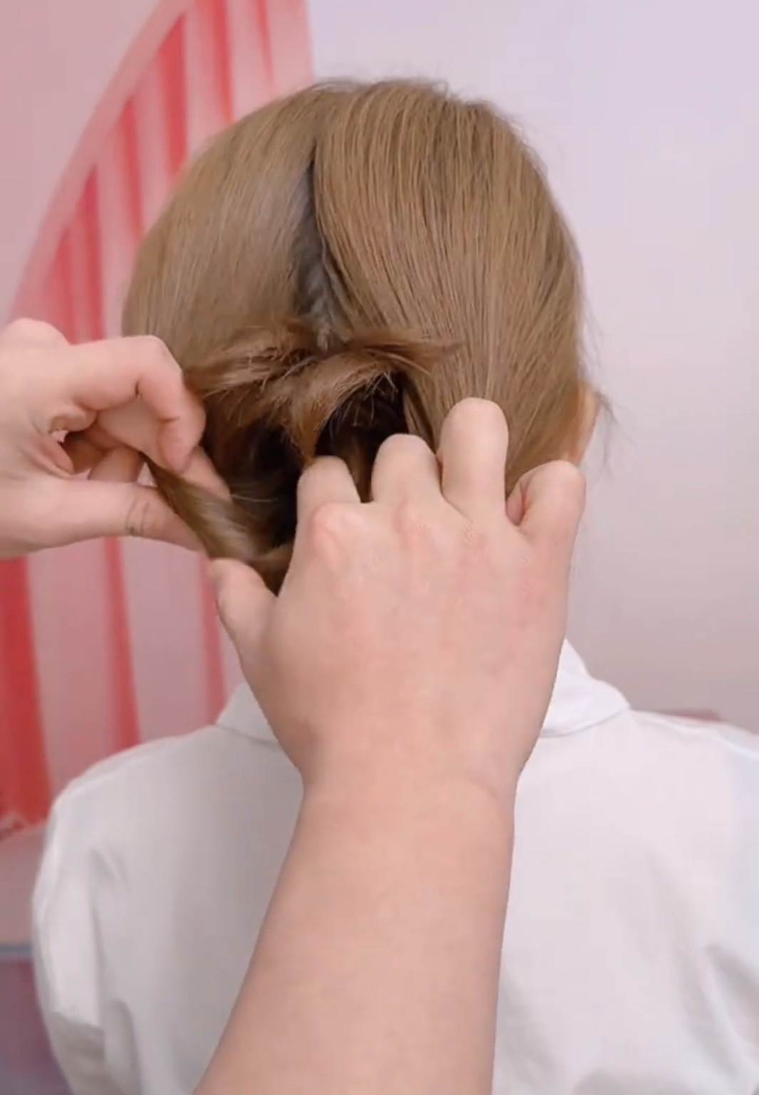 把髮圈下方的馬尾，往拉出來的洞裡塞。