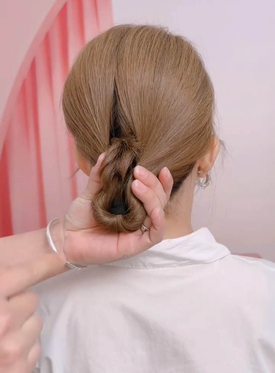 用手掌捉實整個髮髻，將左右頭髮往中間聚攏。