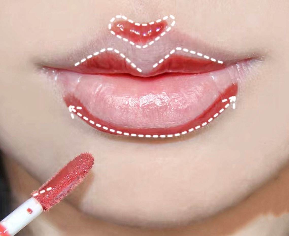 拿出唇釉在唇峰處畫個V字、下唇處畫C字。