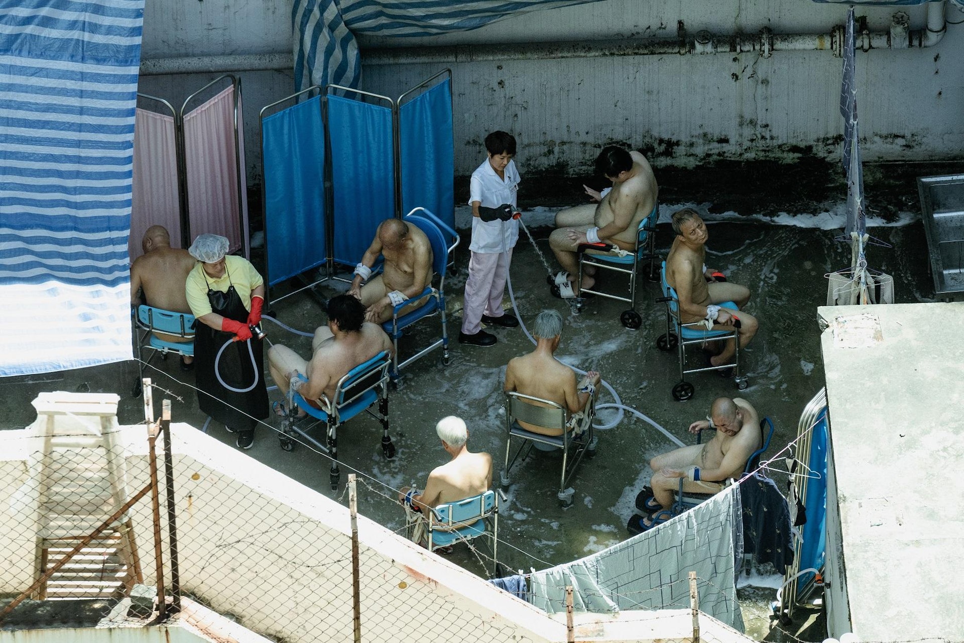 寶珮如在露天地方用水喉為院舍病人沖身。