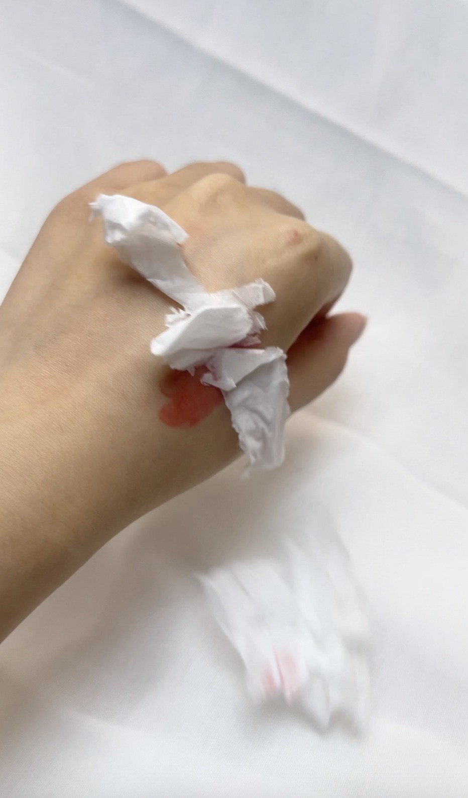 測試黏笠度，將碎紙放在塗上脣膏的手。