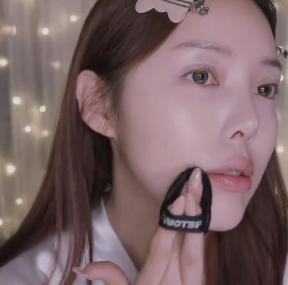 在額頭、蘋果肌、人中、下巴掃上提亮粉。