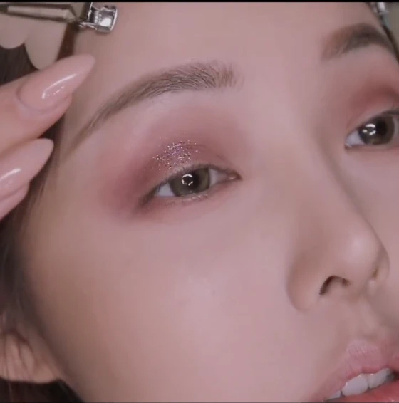 選擇色飽和的啡紅色的眼影順着眼型掃上。