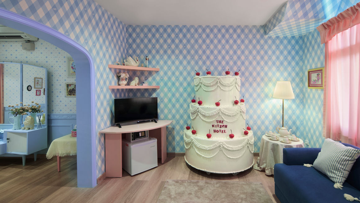 牆上是白藍相間的格紋壁紙，搭配一個超可愛的櫻桃香草蛋糕裝飾，房間裡還飄著淡淡的香草味