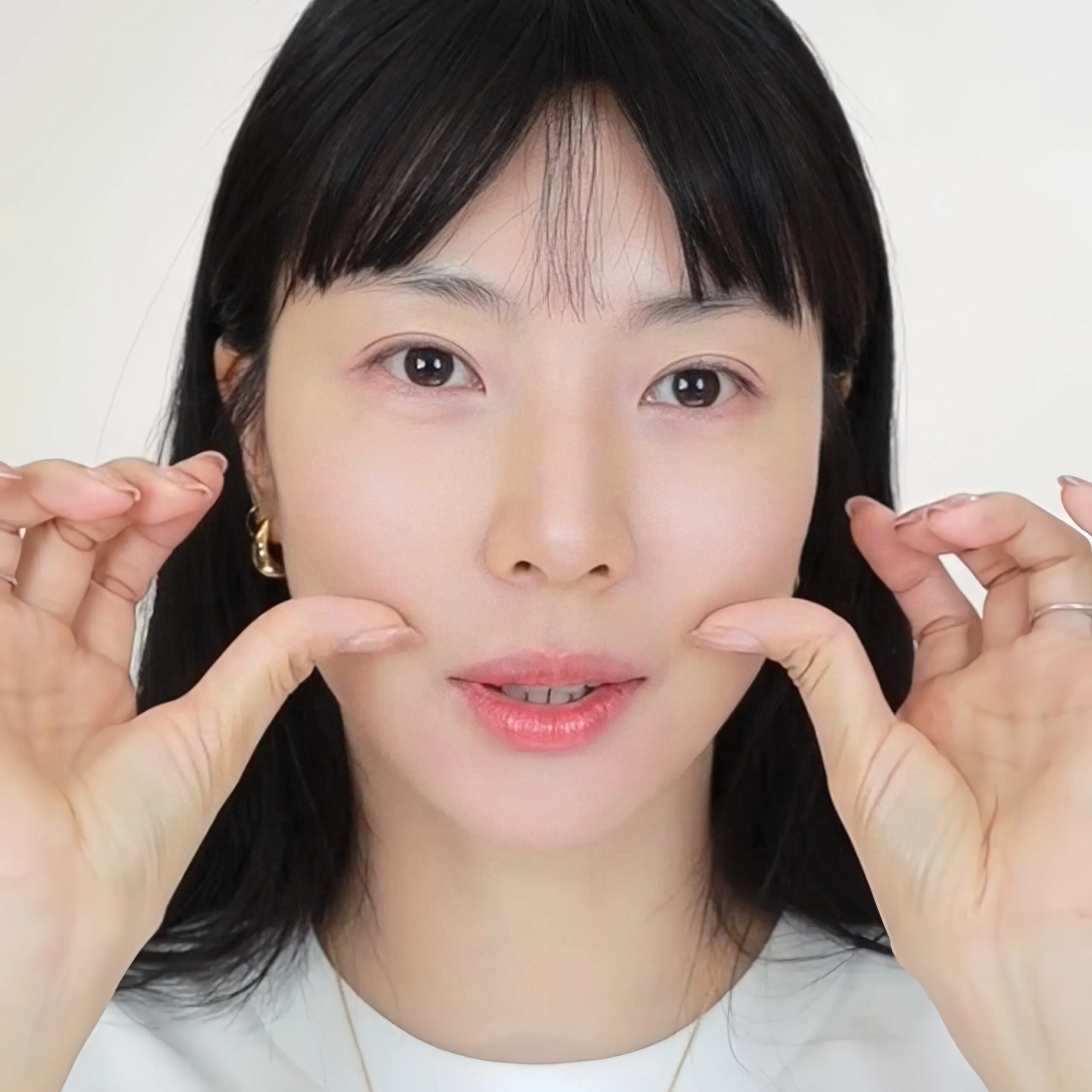 用大拇指指腹提拉面部。