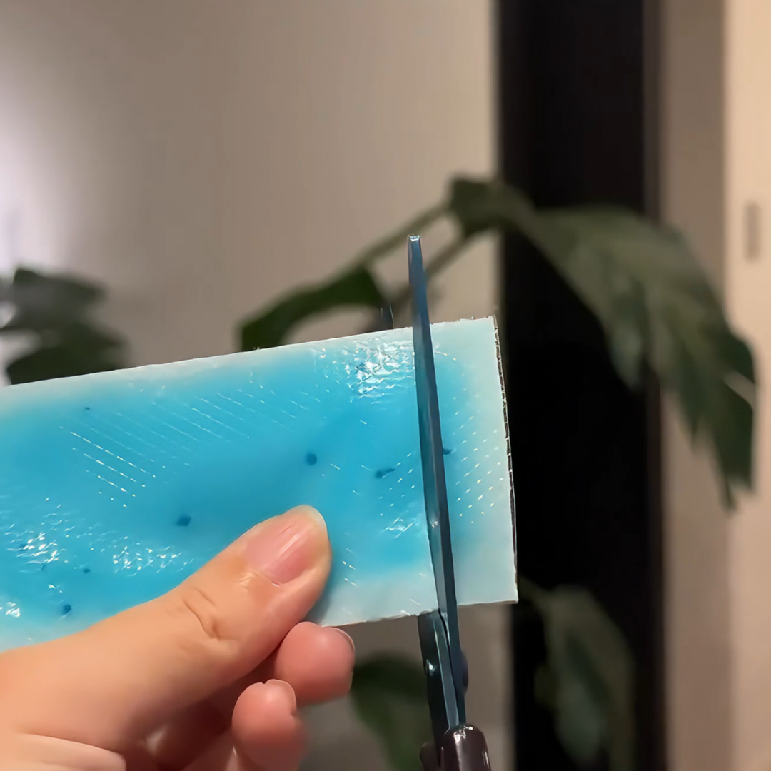 剪下一小片退熱貼，輕輕貼在尾指上。